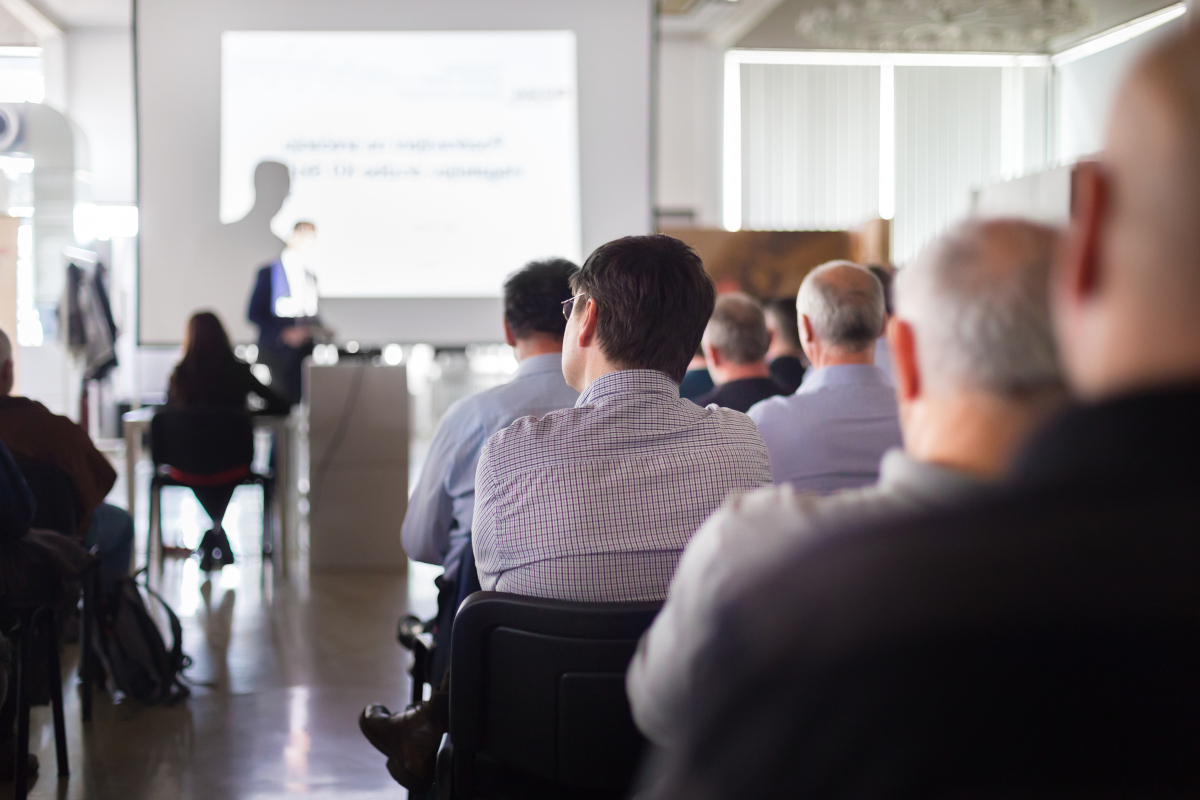 People paying attention to a presentation going on at a business convention.